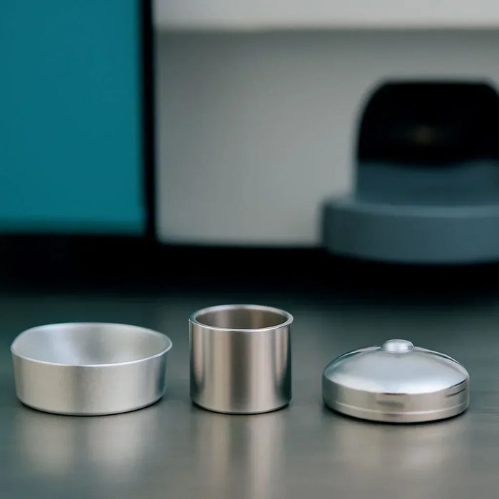 Assortment of PerkinElmer DSC sample pans illustrating critical technical specifications like material, volume, and flatness that influence thermal analysis accuracy.