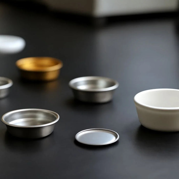 Various DSC sample pans for thermal analysis, showcasing different materials and sizes for laboratory research.